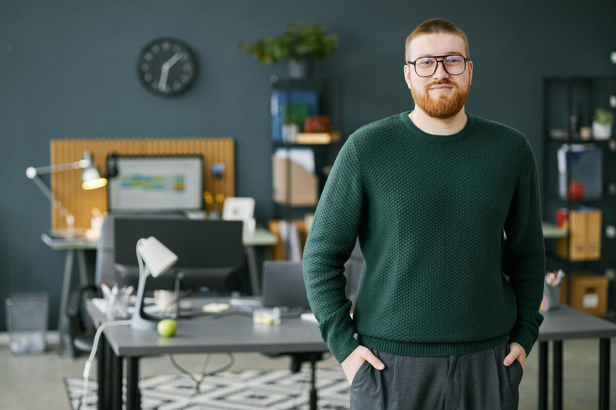A man standing with hands in pockets in a professional office environment