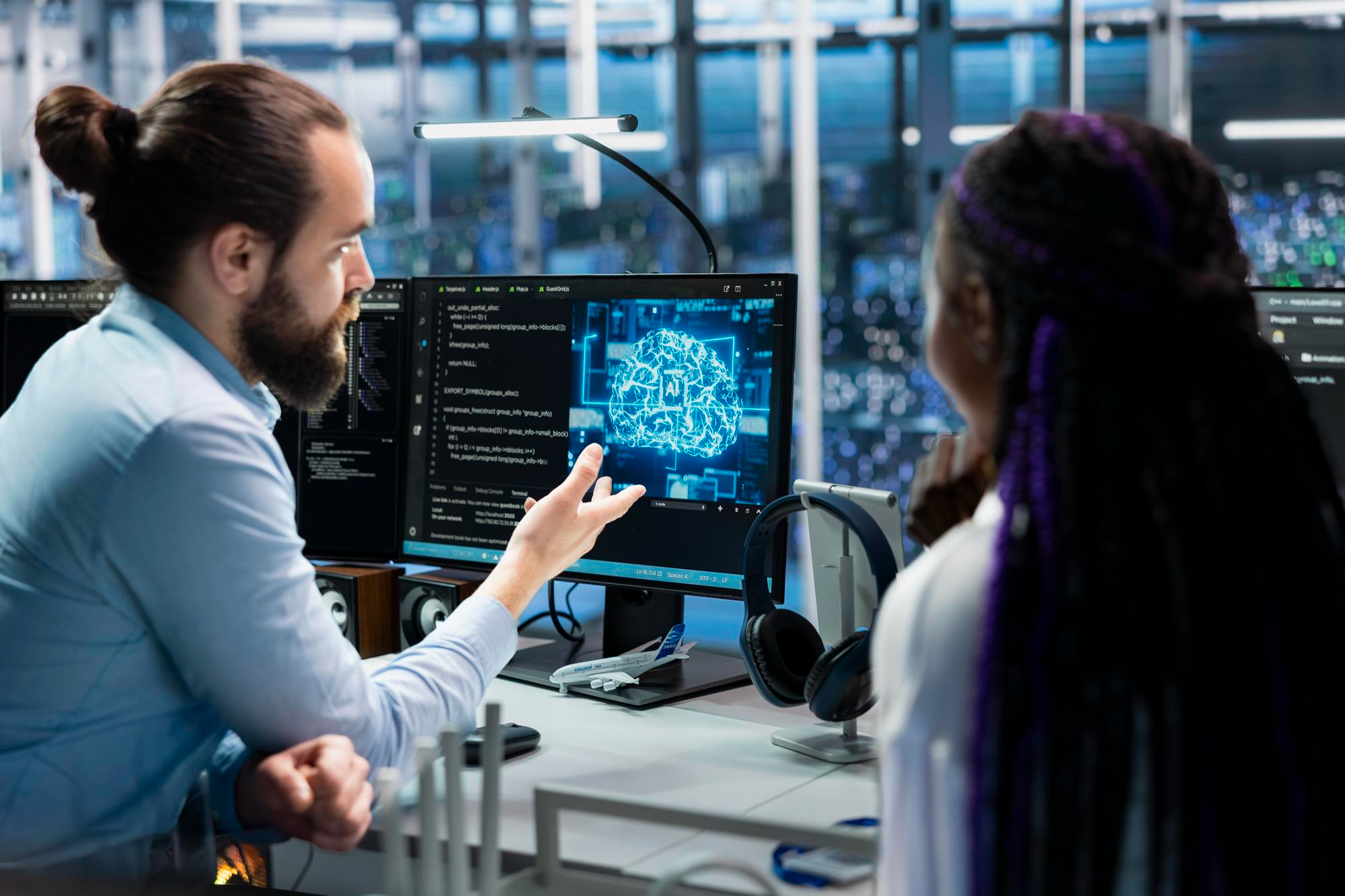 Two professionals discussing AI development on a computer screen together